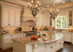 a large kitchen with an island and chandelier hanging from it's ceiling