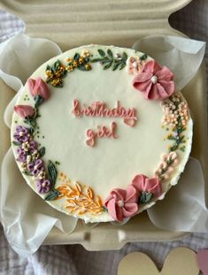 a birthday cake decorated with flowers and the words happy birthday girl on it in a box