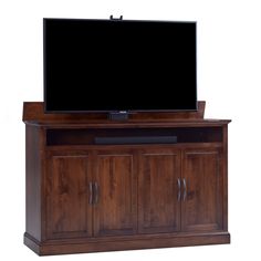 a flat screen tv mounted on top of a wooden cabinet