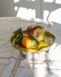 a plate with cake, oranges and other fruit on it sitting on a table