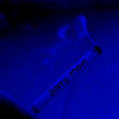 a toothbrush with the word sorry written on it in black ink against a blue background