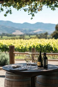 two wine glasses sitting on top of a wooden barrel