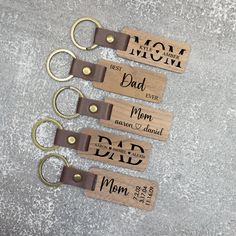 four wooden keychains with the words mom and dad written on them