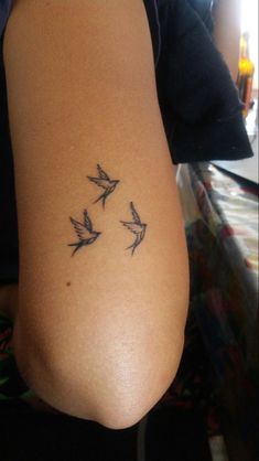 a woman's arm with three birds on it