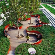 people are sitting on benches in the grass near trees and stairs that have been designed to look like waves