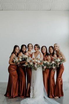 a group of women standing next to each other holding bouquets in front of them