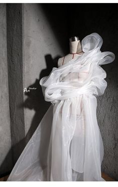 a mannequin with sheer white fabric draped over it