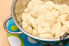 a pot filled with food sitting on top of a blue and white table cloth next to a