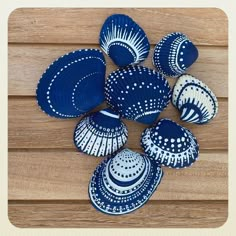 several blue and white seashells on a wooden surface