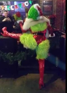 a woman dressed in green and red is dancing