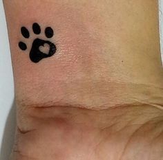 a small paw tattoo on the wrist