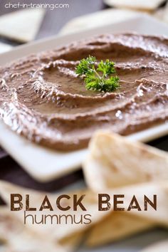 a white plate topped with chocolate hummus next to tortilla chips