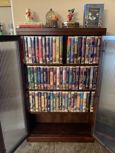 a book case filled with lots of books on top of a floor next to a wall