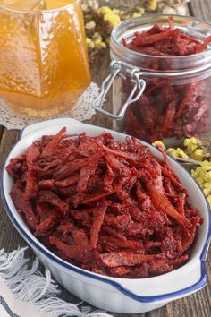 a bowl filled with beets next to a jar of honey