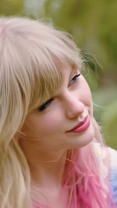 a blonde haired woman with blue eyes and pink hair