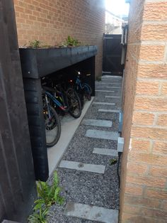 there are many bikes parked in the bike storage area on the sidewalk near the building