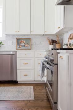 a kitchen with white cabinets and stainless steel dishwasher in the center, along with an area rug on the floor