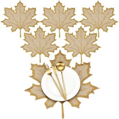 a white plate topped with golden leaves next to a fork and knife