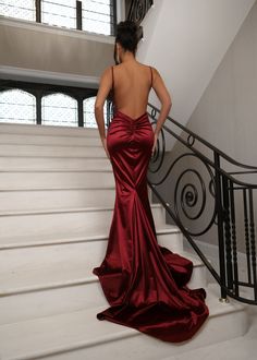 Our Love Affair Satin gown in Wine features a silky satin fabric, ruched back design and a deep V neckline to give you the perfect contoured shape. With its luxurious satin material, the Love Affair ball gown is the perfect figure-hugging maxi dress for prom season. The satin gown drapes perfectly into a fishtail design on the lower half of the maxi dress which is key for those picture-perfect prom pictures. Pair with gold jewellery and a matching gold bag to win best dressed at your black-tie a Red Silk Prom Dress, Dark Red Prom Dress, Wine Red Prom Dress, Red Backless Dress, Red Prom Dress Long, Wine Red Dress, Silk Prom Dress, Dress For Prom, Red Satin Dress