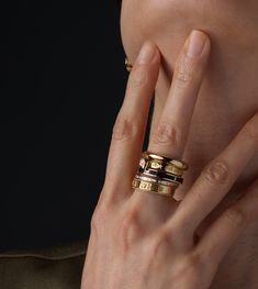 a close up of a person's hand with two rings on their fingers,