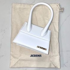 Jacquemus - Le Chiquito Moyen (White) Medium-Size Leather Handbag // Brand New With Tag * This Includes The Handbag Itself, Adjustable Straps, The Tag, And The Dust Bag. * The Linings And Glue Of The Leather As Well As Some Scratches On The Metal Hardware Are Normal In All Jacquemus Bags, Images Are Included. Please Feel Free To Send The Images For Authentication. * Bought This At Around $980, Including Additional Taxes, Duties, And Customs. * The Whole Package Will Be Recorded At The Carrier Fa Bags Jacquemus, Jacquemus Bags, Luxury Bag Brands, Jacquemus Bag, Purple Backpack, Top Handle Handbags, Celine Luggage Bag, Bag Trends, Givency Antigona Bag