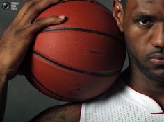 a man holding a basketball over his shoulder