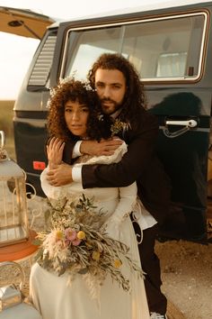 a man and woman hugging each other in front of a van