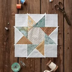 a table topped with lots of different types of crafting supplies on top of a wooden floor