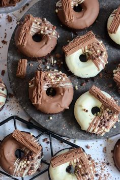 chocolate donuts with white frosting and sprinkles are on a tray