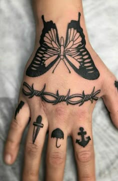 a person's hand with tattoos on it and a butterfly tattooed on the palm