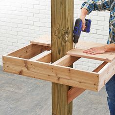 a man sanding wood with a power drill