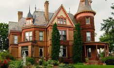 an old brick house with ivy growing on it's roof and two story windows