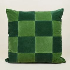 a green checkered pillow sitting on top of a white table