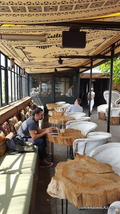 a man is sitting on a bench next to some tables