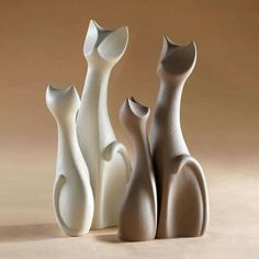 three white vases sitting next to each other on a table