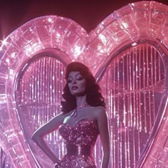 a woman standing in front of a giant heart shaped object with her hands on her hips