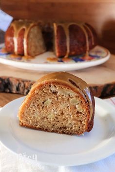 a piece of cake sitting on top of a white plate next to a loaf of bread