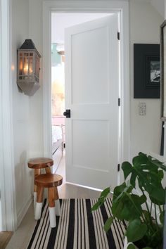 a white door with a black and white striped rug on the floor next to it