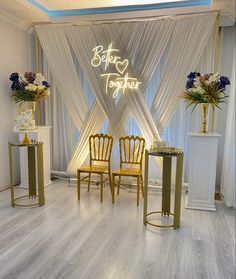 two chairs and a table in front of a white curtained wall with the words better together on it