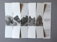 four pieces of folded paper with mountains in the background and text on each one side