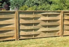 a wooden fence in the middle of some grass