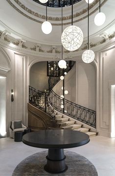 an elegant staircase with chandeliers and circular lights