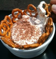 a bowl filled with whipped cream and pretzels