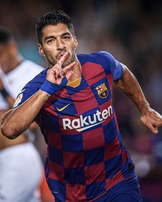 a soccer player with his hand on his mouth and the ball in front of him