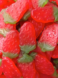 a close up view of some red and green gummy bears with water droplets on them