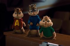 three chipmuns are standing on top of a desk