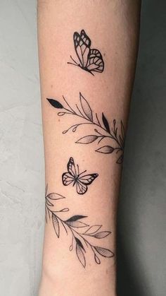 a woman's foot with butterflies and leaves tattoo on the left side of her leg