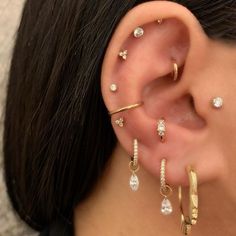 a close up of a person with ear piercings on their ears and behind the ear