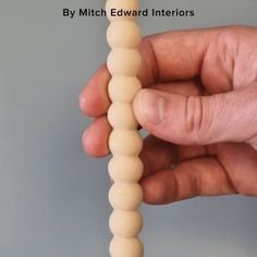 a person holding a wooden bead in their hand