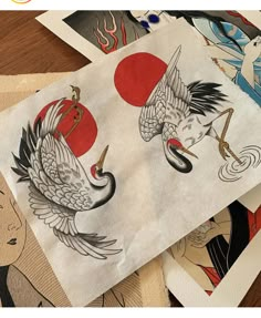 several different designs on paper with japanese characters in the background and an image of two cranes